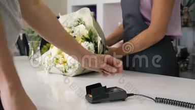 人在花店买花束在支付终端刷卡支付，双手特写..